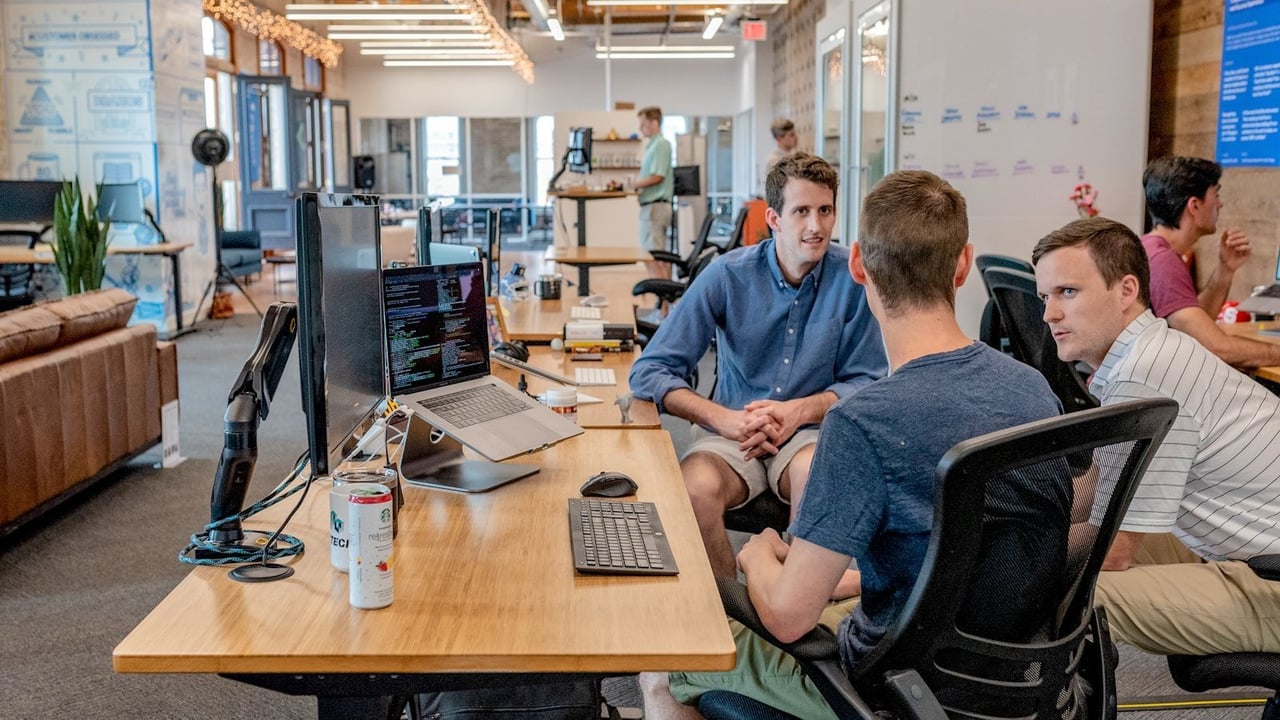 People discussing a plan around a desk